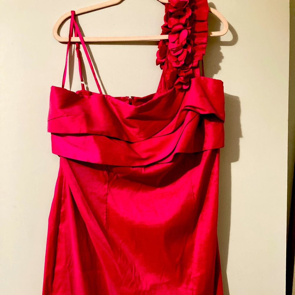 Fun short cocktail dress with ruffled sleeve. Stretchy material in fuchsia.